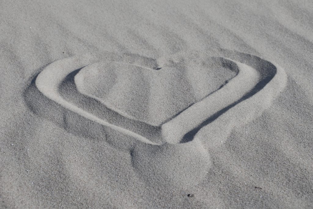 Ein Herz, mit dem Finger in Sand gemalt